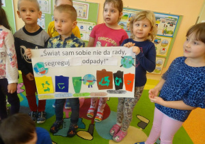 Grupa dzieci stoi z plakatem ekologicznym.